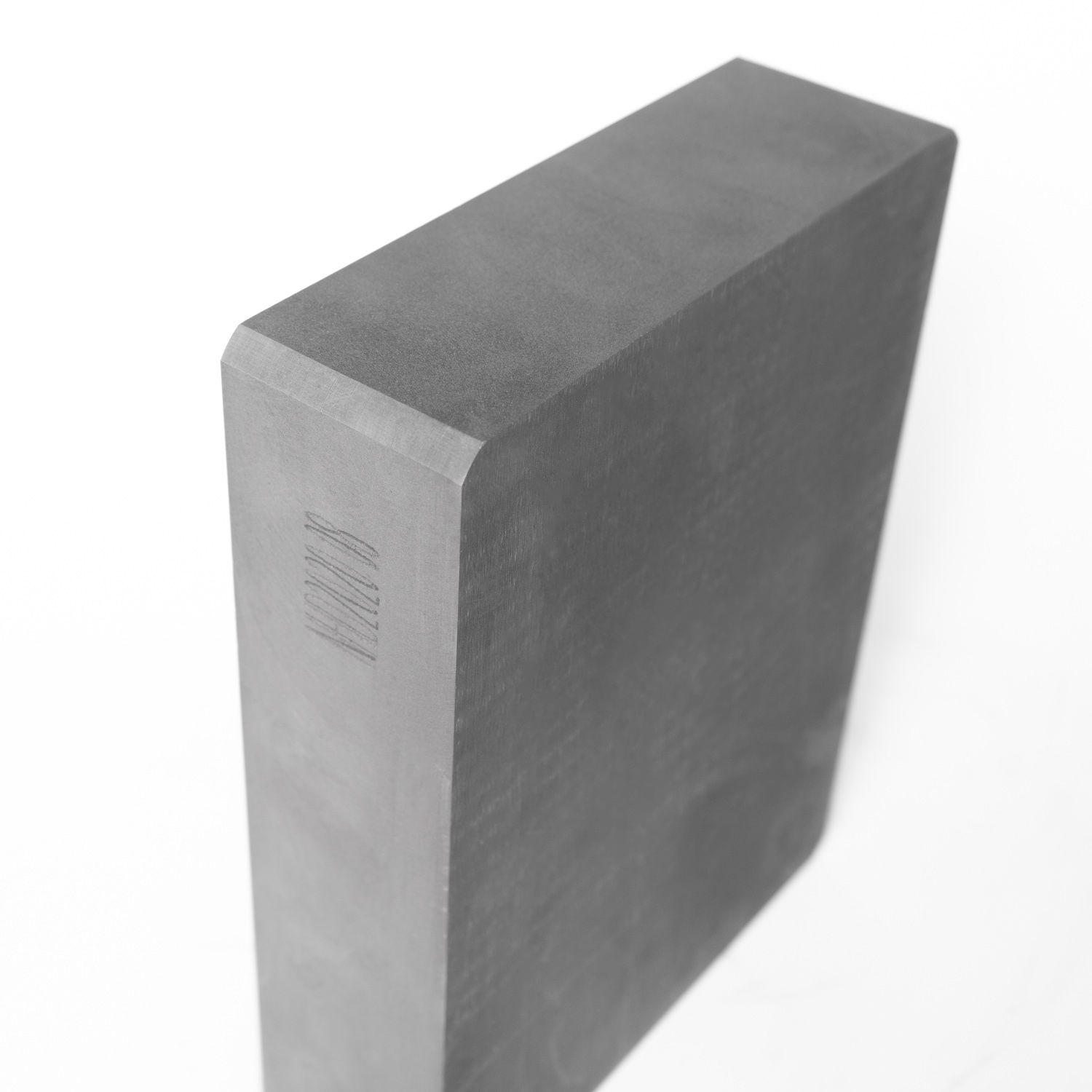 Side view of a graphite block with engraved identification mark, indicating traceability and quality control