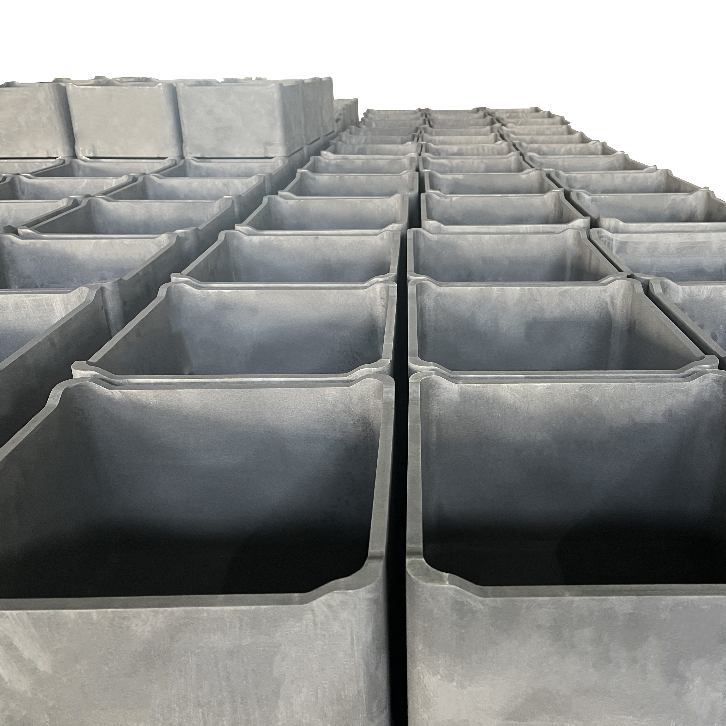 Large batch of isostatic graphite saggers in perspective stack showing consistent quality and uniform dimensions for high-volume powder metallurgy orders