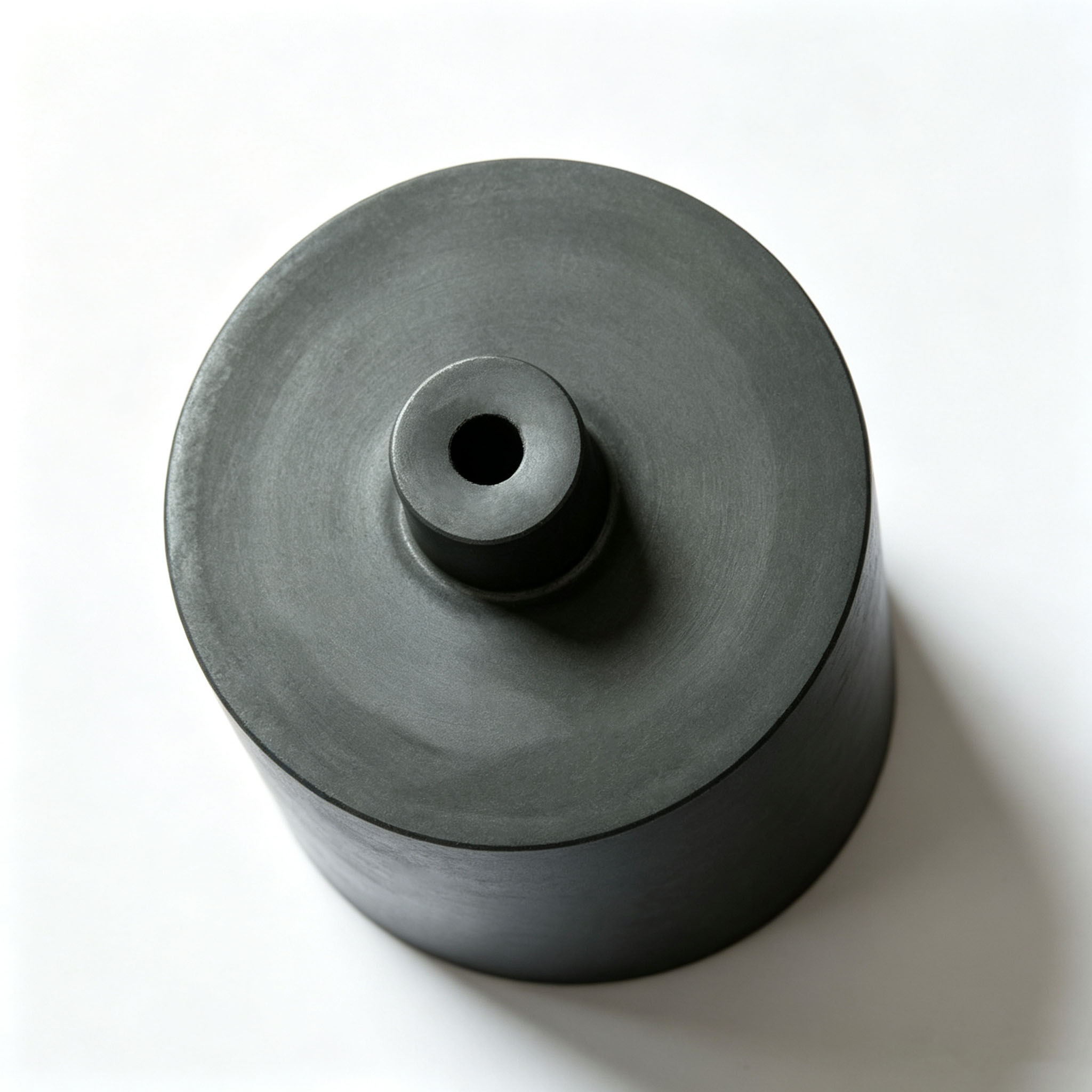 Top-down close-up of high purity straight graphite crucible, smooth precision machined central discharge spout hole, dense isostatic graphite material to resist high temperature molten metal erosion for continuous casting equipment